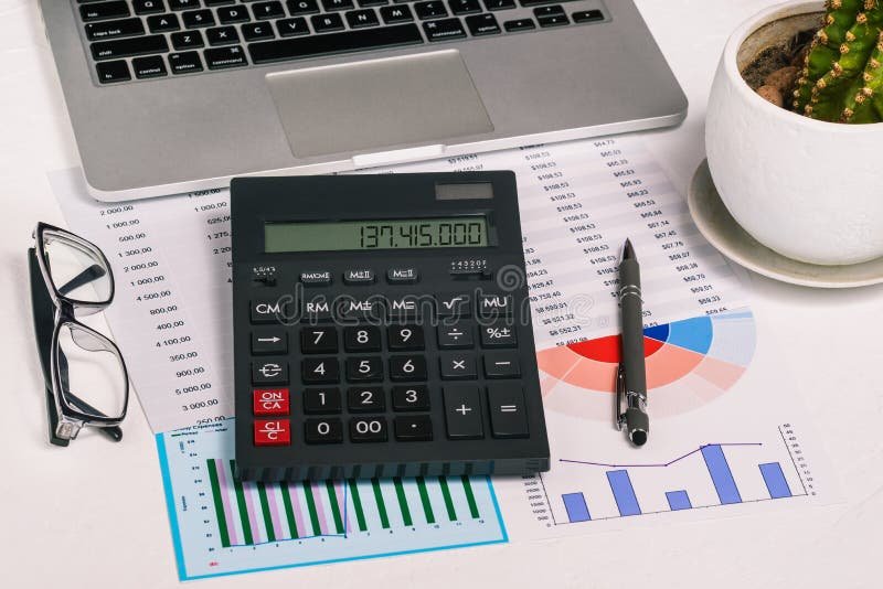 calculatrice avec documents financiers et ordinateur