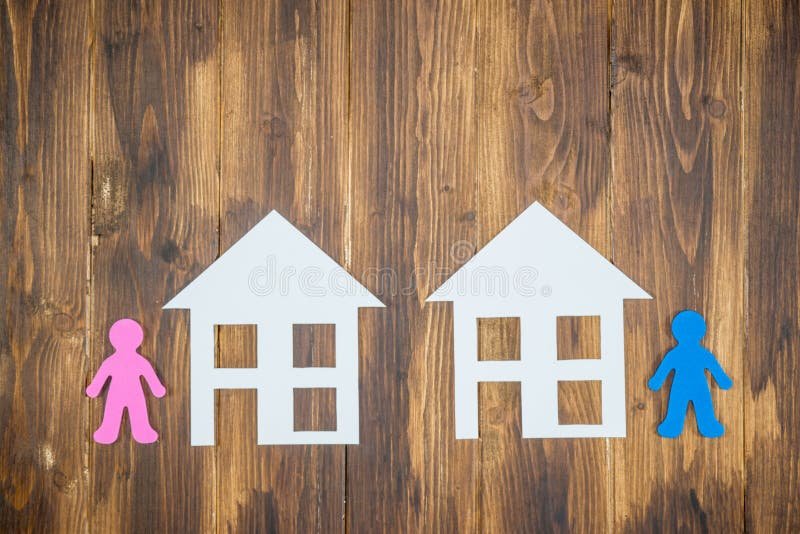 Comment se Désolidariser d’un Prêt Immobilier Lors d’un Divorce 2 couple se separant avec maison en arriere plan