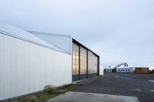 maison moderne integree dans un grand hangar industriel