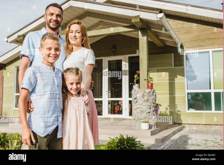 parent et enfant souriant devant une maison