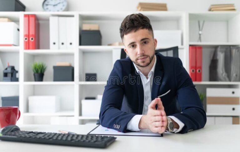 personne devant un bureau avec documents et ordinateur