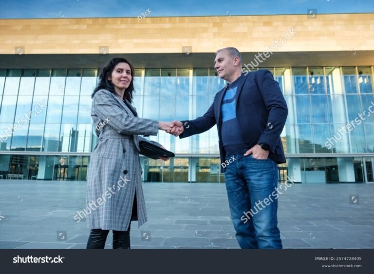 poignees de mains devant batiment entreprise moderne
